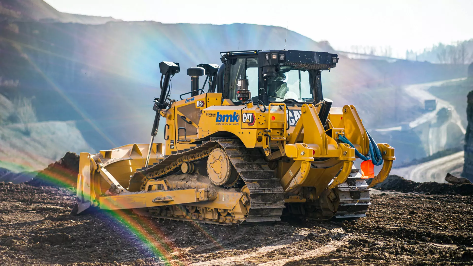 CAT D6XE im Steinbruch mit einem Regenbogen