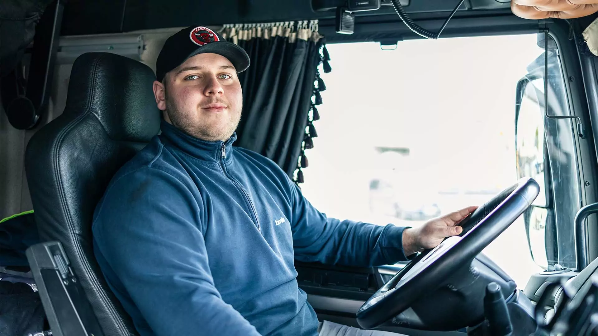 Tim Krottenthaler im Fahrerhaus eines bmk LKW